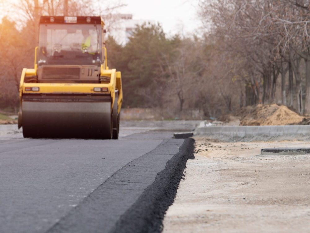 The vibratory roller levels the asphalt pavement.